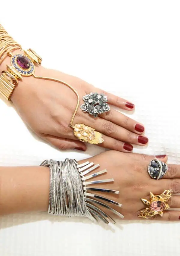 Elegant female hands adorned with stylish rings and bracelets on a white background.